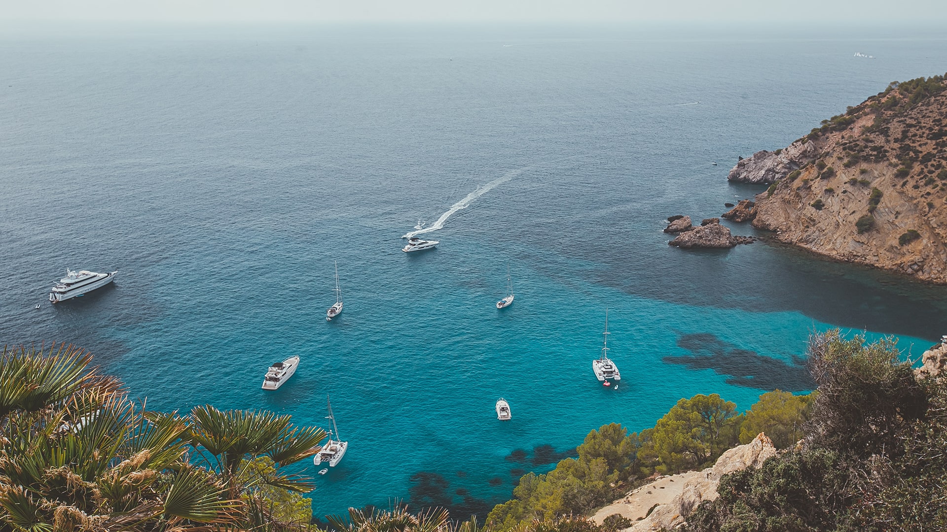 Des yachts et voiliers mouillent dans une crique en Méditerranée