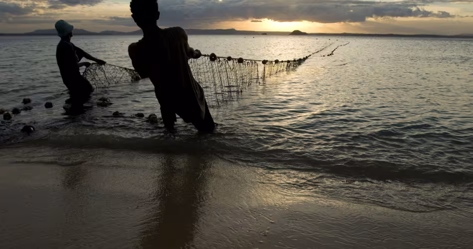 Des pêcheurs sortent leurs filets de l'eau au crépuscule, plage de Ramena à Antsiranana, Nord de Madagascar