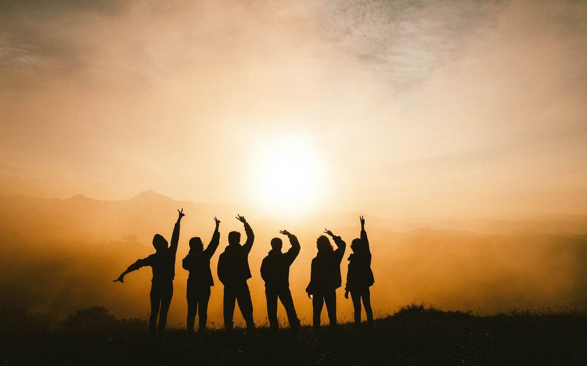 Six personnes admirent un coucher de soleil