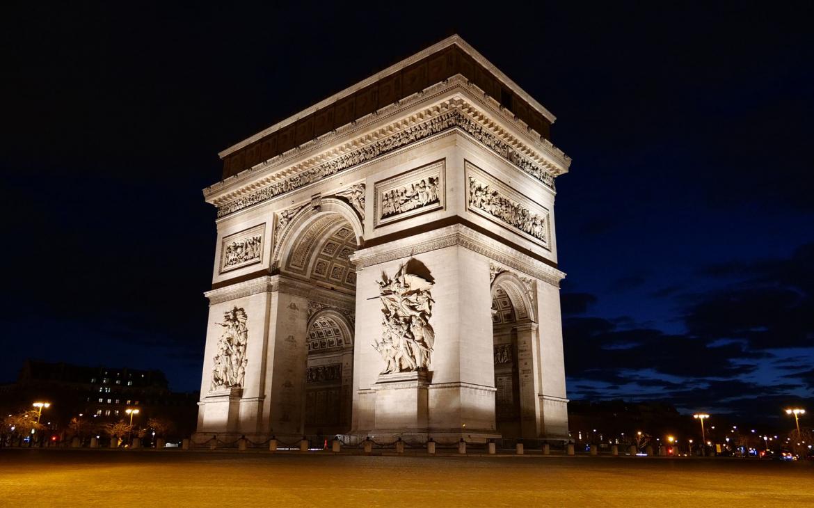 L'arc de triomphe est allumé en pleine nuit.