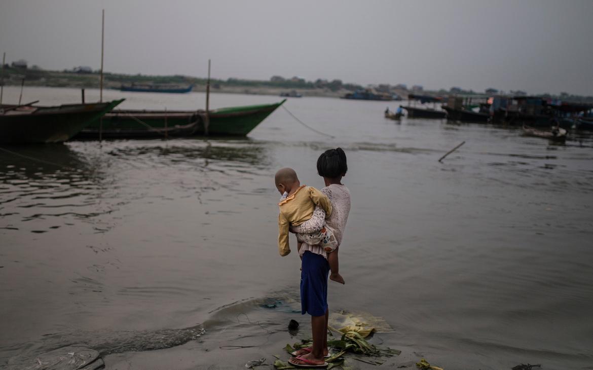 Une fille portant son petit frère à Myanmar