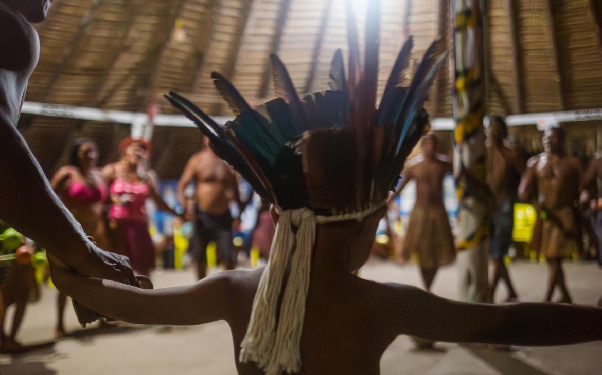 Des hommes, des femmes et des enfants dansent lors d’un rituel organisé dans la tente centrale de la communauté du village de Vista Alegre do Capixauã, Santarém, Pará, Brésil