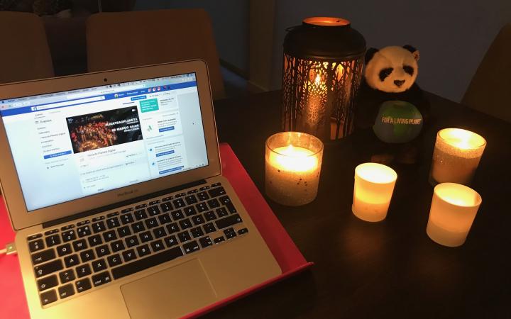 Lumière éteinte, ordinateur et bougies à l'occasion d'Earth Hour 2020.