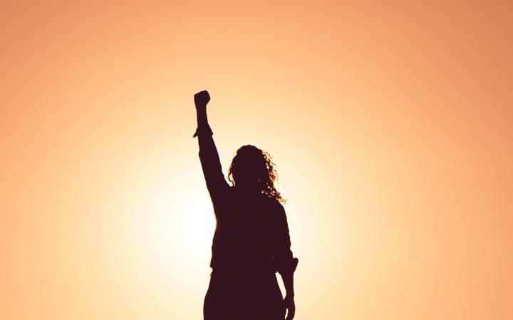 Femme qui lève le point pour montrer son engagement