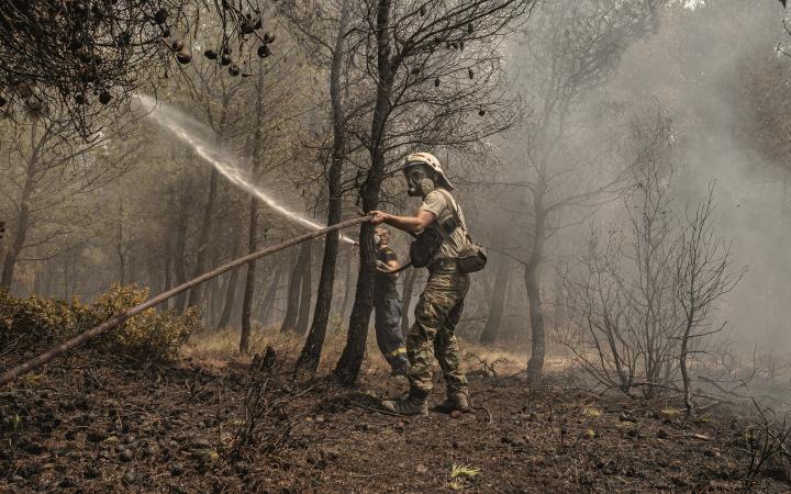 Un pompier qui jette de l'eau pour tenter d'éteindre les flammes