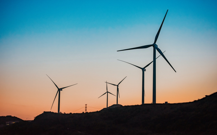 Champ d'éoliennes au coucher de soleil