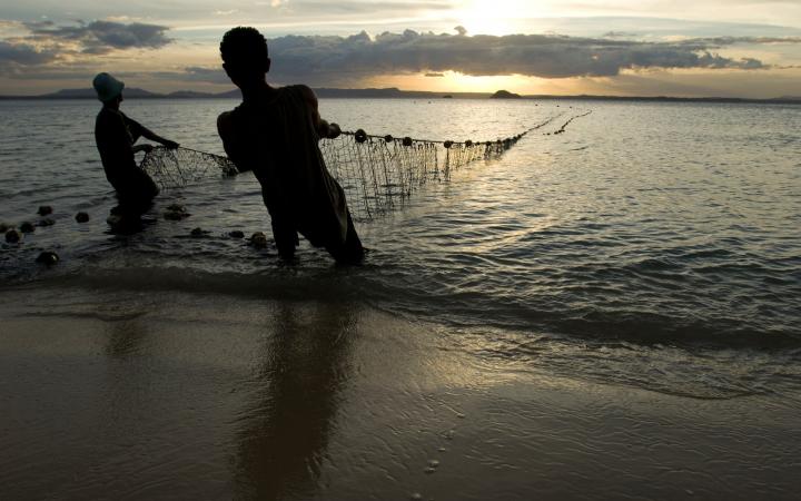 Des pêcheurs sortent leurs filets de l'eau au crépuscule, plage de Ramena à Antsiranana, Nord de Madagascar