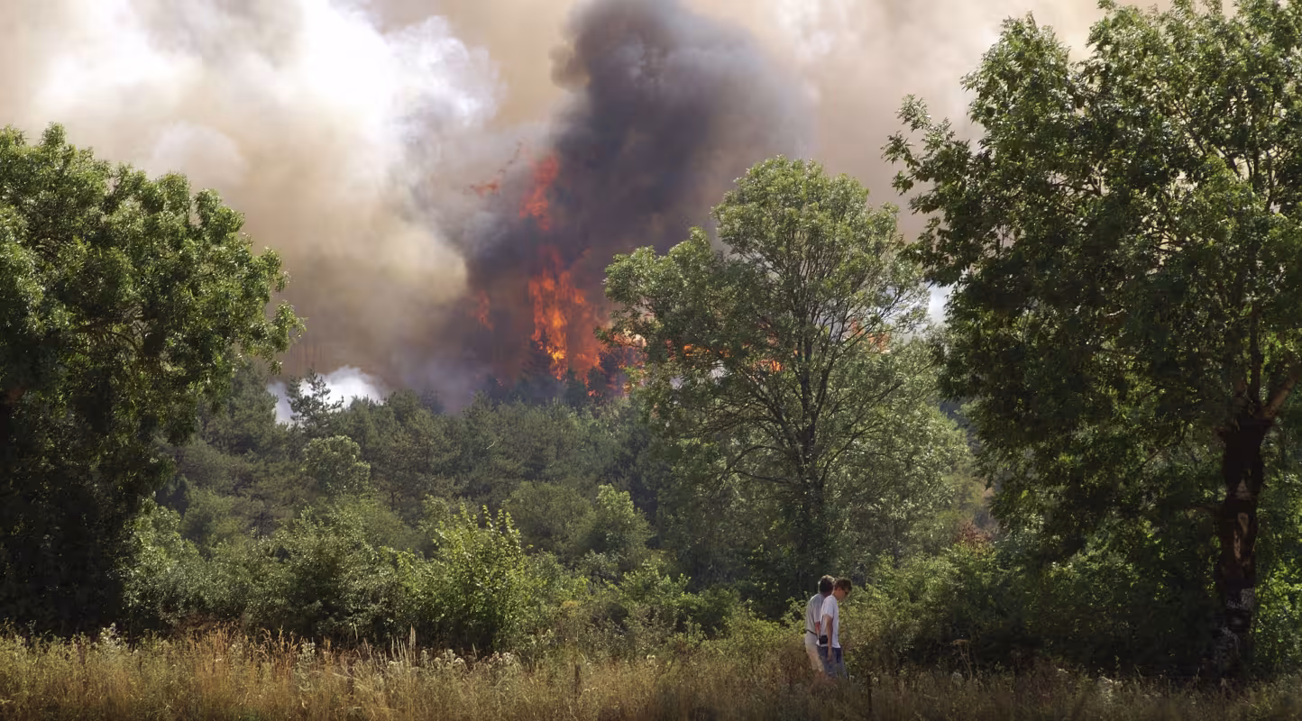 Des habitants fuient leur maison menacée par l'incendie. Des feux de forêt ont fait rage dans le sud de la France durant l'été 2003.