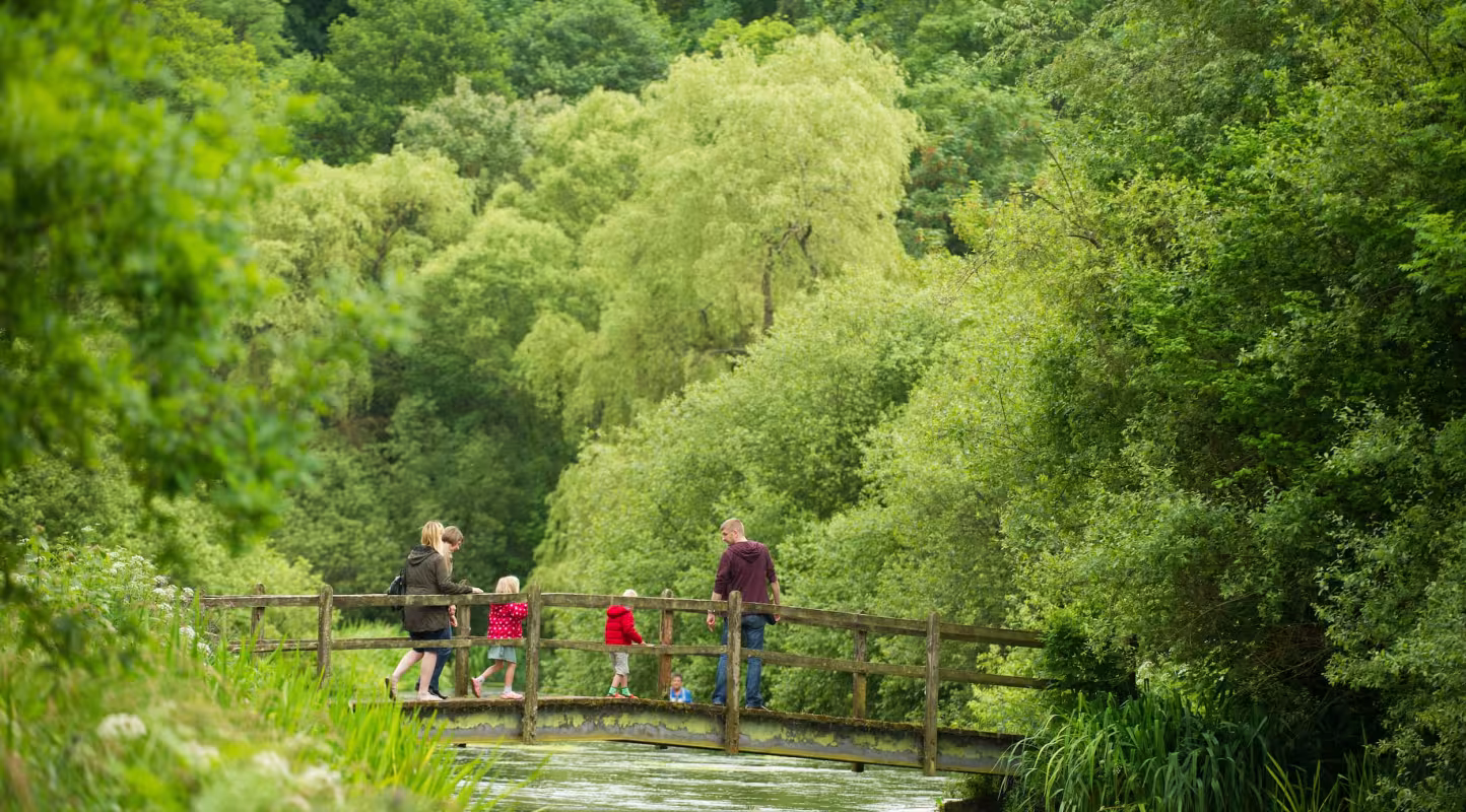 Une famille traverse un pont sur la rivière Itchen, dans le Hampshire (Royaume-Uni).
