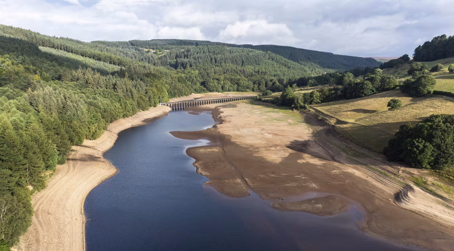 Vue aérienne du réservoir de Ladybower montrant un niveau d'eau extrêmement bas lors d'une sécheresse durant la canicule estivale, dans la vallée de la Derwent (Derbyshire, Royaume-Uni).