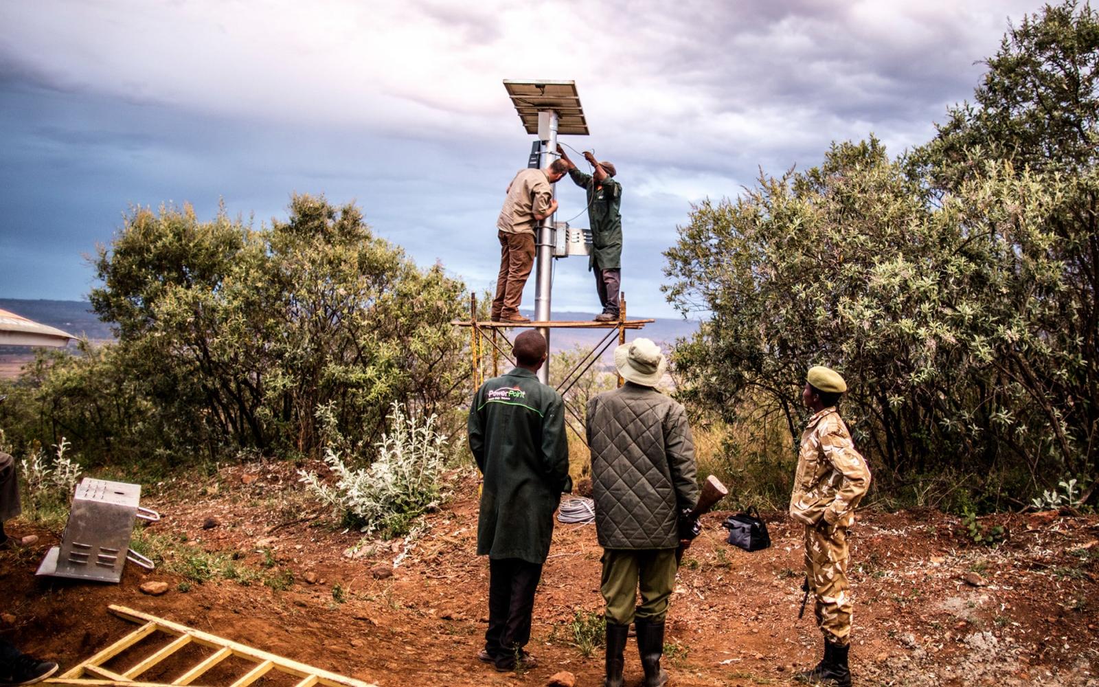 Des ingénieurs installant des panneaux solaires sur une caméra thermique FLIR pour lutter contre le braconnage des éléphants (Kenya)