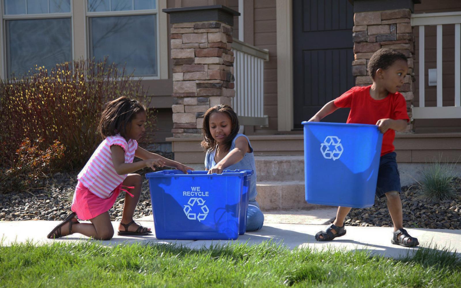 Enfants avec des bacs de recyclage des déchets 