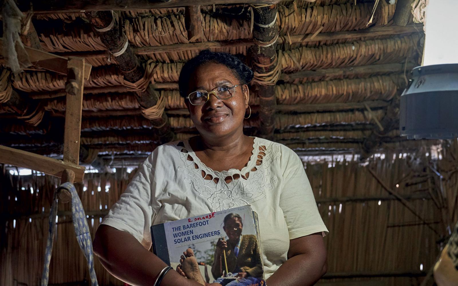 Yolande, une grand-mère "solaire"  tient son livre d'apprentissage du Barefoot college (Madagascar) 