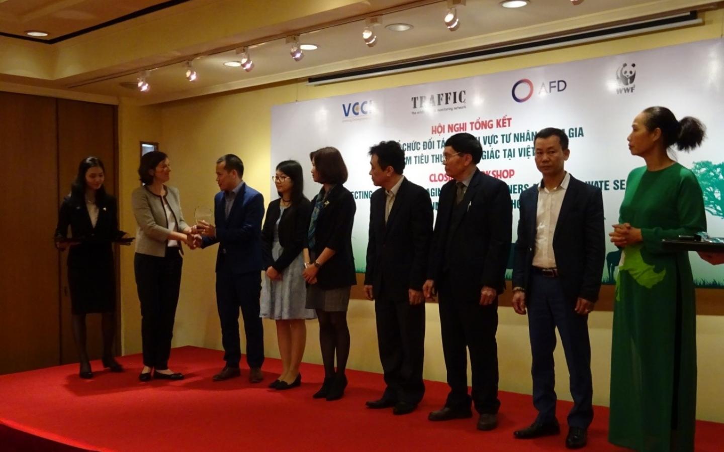 Une représentante du projet remettant une récompense aux dirigeants qui ont activement encouragé leurs personnels à ne pas utiliser de cornes de rhinocéros (Vietnam).
