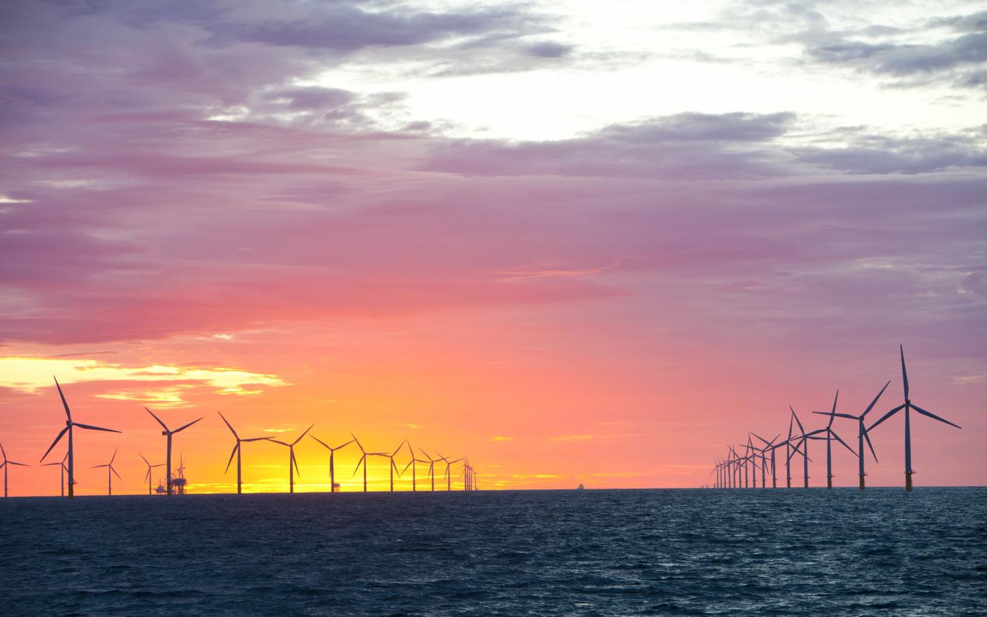 Coucher de soleil sur un parc éolien offshore proche de Cumbria, Royaume-Uni.