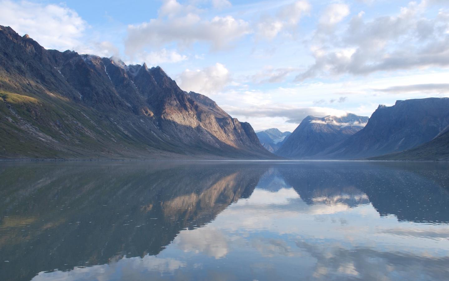 Les montagnes et les nuages de l'île Baffin se reflètent dans l'eau à Nanavut au Canada