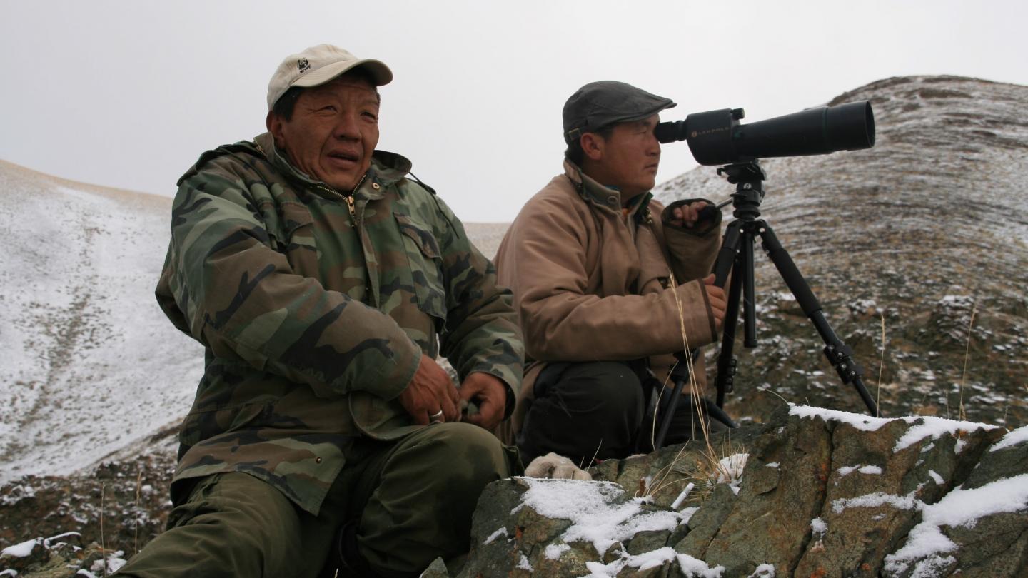 Berger local dans les plateaux de l'Altai en train de surveiller des panthères des neiges
