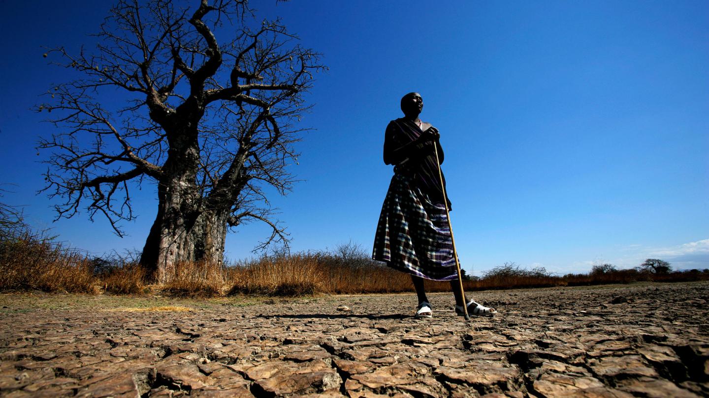 Un masaï debout sur des terres asséchées (Tanzanie)