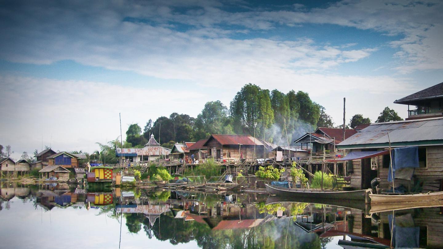 Habitations locales aménagées au bord d'une rivière (Indonésie)
