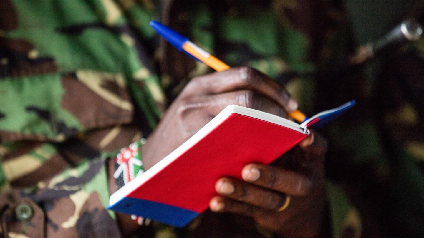 Ranger prenant des notes dans le cadre d'une formation WWF sur la caméra thermique FLIR pour lutter contre le braconnage des éléphants, Réserve nationale de Maasai Mara (Kenya)