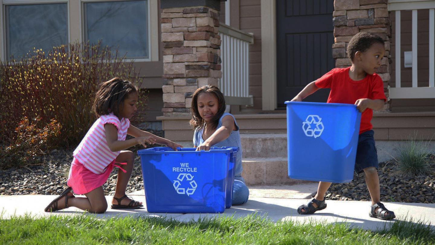 Enfants avec des bacs de recyclage des déchets 