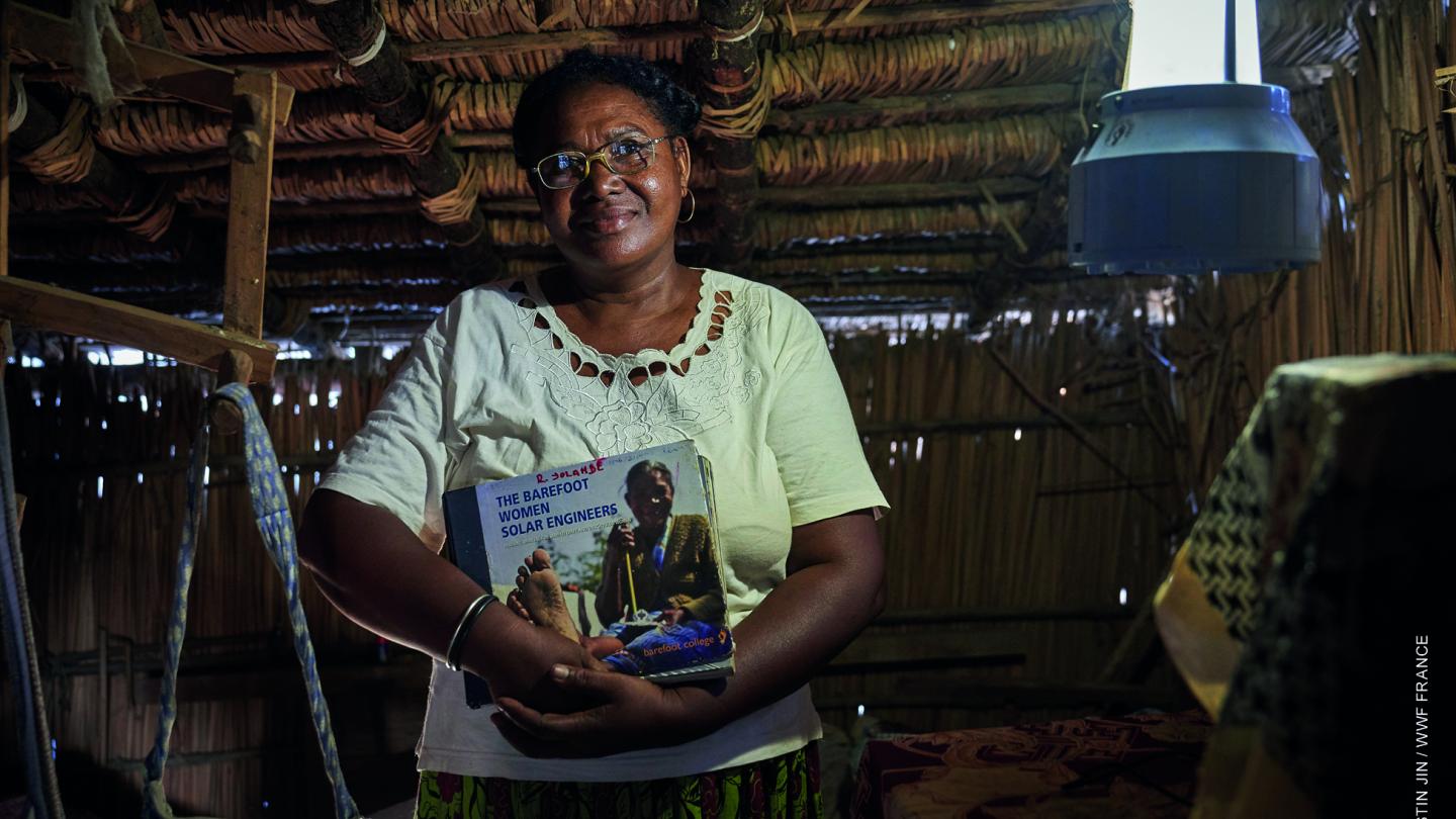 Une grand-mère "solaire"  tient son livre d'apprentissage du barefoot college (Madagascar) 