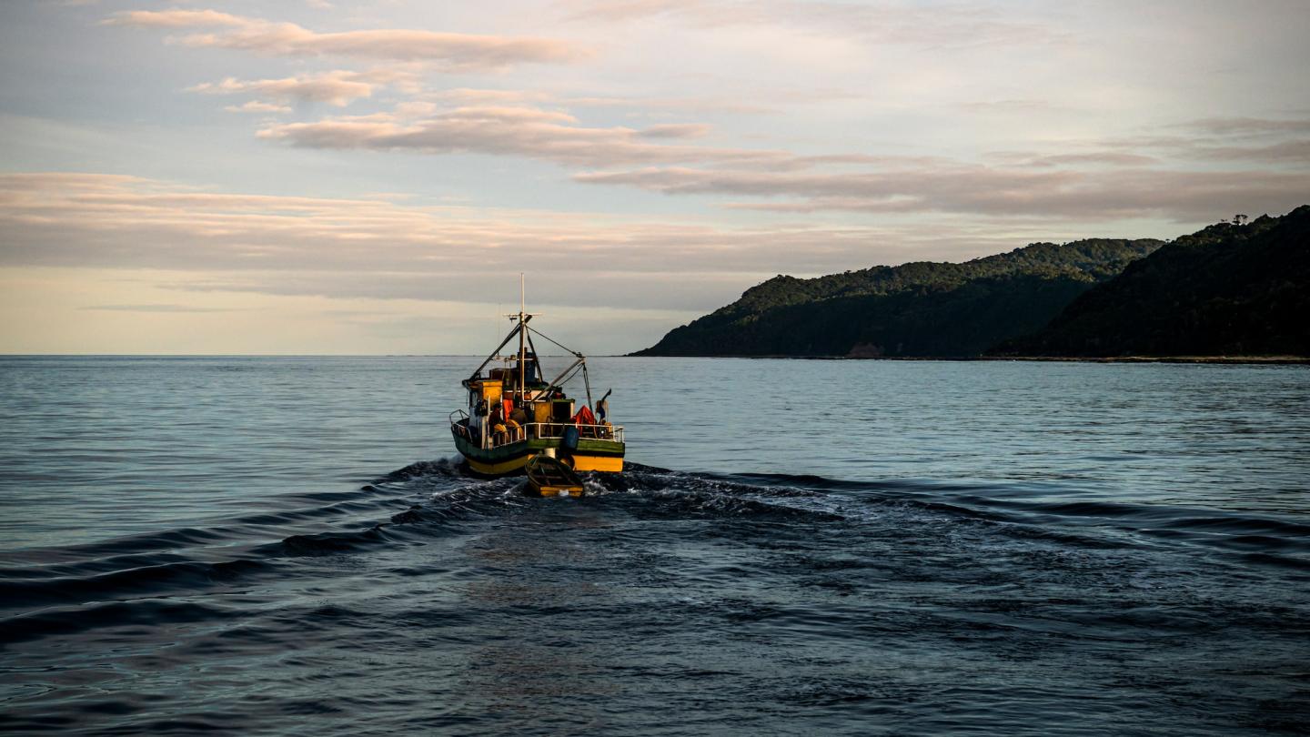 Bateau de pêche artisanal qui navigue au coucher du soleil