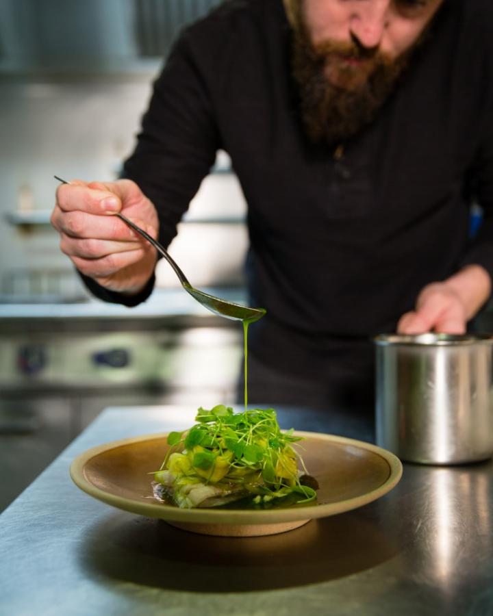 Florent Ladeyn en train d'arroser d'huile de poireaux son plat