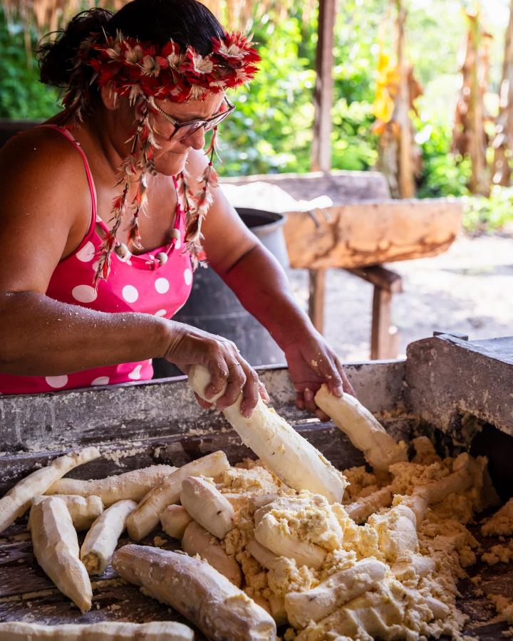 Irenilse Batista Sousa, cheffe du village d'Aldeia Vista Alegre do Capixauã à Santarém, Pará au Brésil, met le manioc cru et pelé à broyer dans la minoterie
